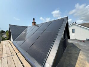 Close-up view from scaffolding of solar panels attached to a slate roof.