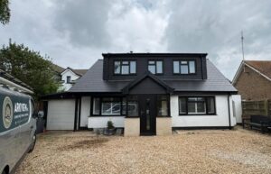 View from the front drive of a chalet bungalow with newly-fitted grey slate tiled roof.