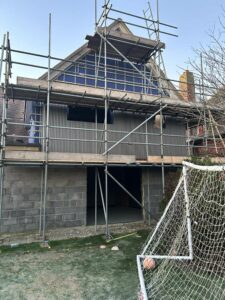 3 storey Scaffolding covers a house extension.