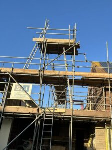 Scaffolding for a new extension being built on the side of a house.