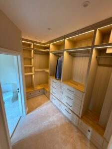 Custom fitted units in a dressing room showing space for hanging and lots of drawers and shelves.